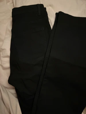 Jeans - Säljer ett par svarta jeans med låg midja och raka ben. 