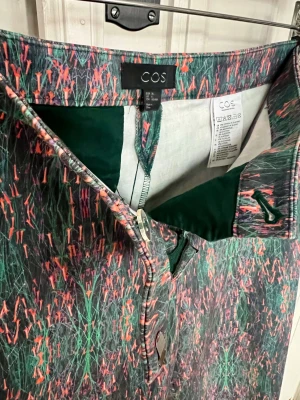 Mönstrade byxor från COS - COS-byxor med unikt mönster och välskräddad design. Modellen är rak med normal tajt passform och normal/hög midja. Materialet är följsamt med lite stretch. Funkar alla årstider, både vardag och fest. Byxan slutar vid ankeln på modellen som är 165cm /strl S. Perfekt byxa för att sticka ut med färg och mönster i kombination med basplagg. 