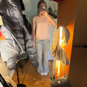 Ljusrosa stickad topp från H&M - Säljer en ljusrosa stickad topp från H&M med rund halsringning och korta ärmar. Toppen har en enkel och clean design med ribbade kanter vid ärmslut och nederkant. 