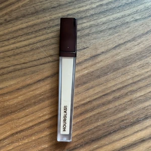 Hourglass Vanish Concealer Beech - 80% kvar i förpackningen, används några gånger! Hourglass Vanish Airbrush Concealer i nyansen Beech. Kommer i en stilren, fyrkantig tub med mörkbrunt lock och genomskinlig kropp som visar den ljusa, beige färgen. Perfekt för att täcka mörka ringar och ojämnheter. Innehåller 6 ml.