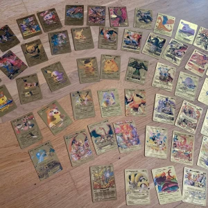 Pokémon samlarkort - guld edition - Cool samling av Pokémon samlarkort i guldutförande! Perfekt för dig som älskar Pokémon och vill ha något unikt i din samling. Här hittar du favoriter som Pikachu, Charizard och Mewtwo. Passar både nya och erfarna samlare – gör din samling ännu mer episk! 51 st med lådan. 