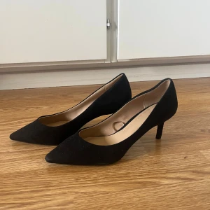 Svarta pumps från H&M, storlek 36 - Säljer ett par klassiska svarta pumps från H&M i storlek 36. Skorna har spetsig tå, låg klack. Perfekta för dig som vill ha en stilren och tidlös look.