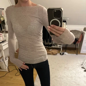 Intimissimi topp - Säljer en beige långärmad topp med slim passform och rund hals. Tunn och mjuk, perfekt att styla med jeans eller kjol. Materialet känns som bomull eller polyester och toppen har en enkel, clean look utan detaljer eller mönster.