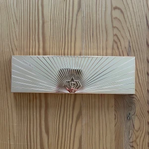 Charlotte Tilbury Pillow Talk ögonskuggspalett - Säljer en lyxig Pillow Talk Instant Eye Palette från Charlotte Tilbury med 12 ögonskuggor i nude, rosa, bruna och lila toner. Paletten har en snygg guldig förpackning med spegel och är perfekt för att skapa olika looks med både matta och skimriga nyanser. Har använt två färger ett fåtal gånger. Köpt för 700 kr.