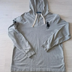Grå tröja från Polo Ralph Lauren - Säljer denna snygga Ralph Lauren tröja som är i perfekt skick. Storlek L. Perfekt för chill dagar eller när du vill ha en clean look.