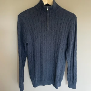  half zip från John Henric - Säljer en mörkblå kabelstickad tröja från John Henric i storlek S. Tröjan har hög krage med half zip-dragkedja och långa ärmar. Perfekt för dig som gillar klassisk och stilren look med lite preppy känsla.