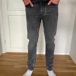 Grå raka jeans från Neuw, 30/32 - Snygga grå jeans från Neuw i modellen Ray Straight. Jeansen har en rak passform och klassisk femficksdesign. Materialet är denim i en tvättad grå nyans med svarta sömmar. Perfekta för dig som gillar en stilren och avslappnad look.