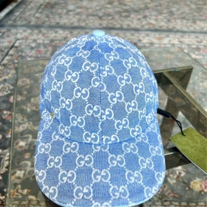 Blå  keps i jeans med GG-mönster - Snygg blå keps i jeansmaterial med vitt GG-mönster över hela kepsen. Justerbar rem bak i ljusblått skinn och liten guldfärgad GG-detalj på sidan. Perfekt accessoar för att lyfta din outfit med lyxig streetstyle.