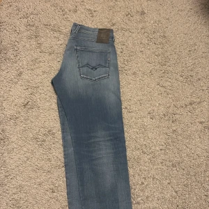  Replay Anbass slim fit jeans blå - Snygga Replay Anbass jeans i ljusblå tvätt, Jeansen är tillverkade i stretchigt denim. 