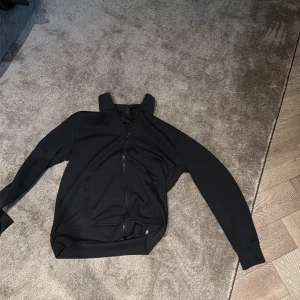 Svart bomberjacka från Armani Exchange - Svart bomberjacka från Armani Exchange med stilren design och diskret AX-logga på bröstet. Jackan har hel dragkedja framtill, två fickor och ribbade muddar vid ärmar och nederkant. Perfekt för dig som gillar minimalistisk och snygg streetstil.