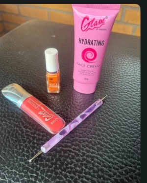 Glam läppglans och ansiktskräm - Säljer ett rött läppglans från Glam of Sweden, en rosa återfuktande ansiktskräm från samma märke och en lila mönstrad sminkpenna. Perfekt för dig som vill ha mjuka läppar och fräsch hy. Läppglanset har en snygg glansig finish. Endast testad 