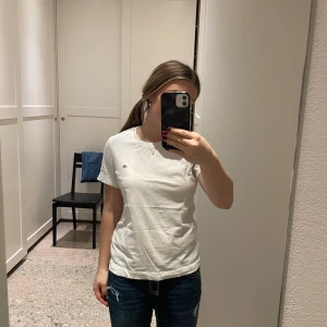 Gant T-shirt  - Säljer en basic vit t-shirt från Gant, som endast är använd någon enstaka gång. Perfekt att ha med ett par snygga jeans eller coola byxor. T-shirten är gjord i bomullsmaterial och väldigt mjuk i tyget. 