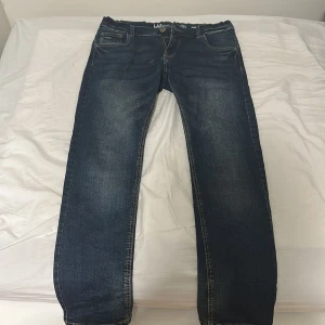 Mörkblå wide jeans från LAB Industries - Snygga mörkblå jeans från LAB Industries i modellen X-Wide. Jeansen har klassisk femficksdesign, dragkedja och raka ben med bred passform. Tillverkade i hållbar denim med snygga slitningar för en cool look.