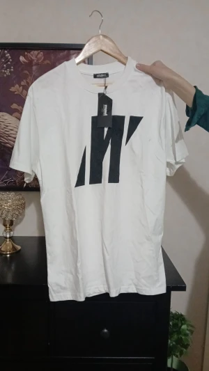 Vit t-shirt med svart tryck från Mavi - Snygg vit t-shirt från Mavi i storlek M med ett stort svart grafiskt tryck på framsidan. Klassisk rund hals och korta ärmar. Köpt från Turkiet.