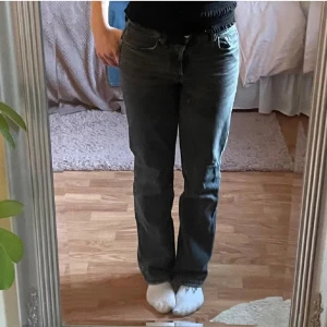 Grå raka jeans från Zara - Säljer ett par grå jeans från Zara med raka ben och klassisk femficksmodell. Jeansen har knappgylf och normal passform, perfekta för en avslappnad stil. Materialet är jeans och färgen är en snygg mörkgrå ton.