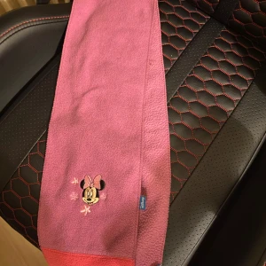 Rosa fleecehalsduk med Minnie Mouse - Söt rosa halsduk i  fleece från Disney med broderad Minnie Mouse och små stjärnor framtill. 