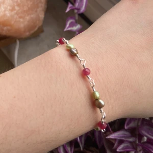 Armband med pärlor och rosa stenar - Fint armband med mix av olivgröna och bruna pärlor samt facetterade rosa stenar. Länkar och lås i silverfärgad stainless steel. Armbandet har en liten bricka med 'S. Steel' ingraverat. Perfekt för dig som gillar färg och unika detaljer.