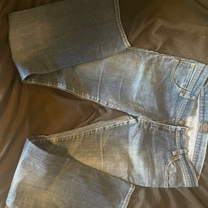 Blå jeans från Crocker W32 L34 - Snygga blå jeans från Crocker, modell CR-324. Klassisk femficksdesign med raka ben och kontrastsömmar. Jeansen har en normal passform och är tillverkade i slitstarkt denimtyg. Perfekt för dig som gillar en tidlös stil.