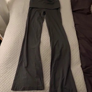 Gråa yogapants från BikBok - Säljer ett par gråa yogapants från BikBok i storlek M. Byxorna har hög midja och är tillverkade i ett mjukt och stretchigt material som sitter skönt på kroppen. Perfekta för en chill och trendig look. Säljer då de inte kommer till användning 💕