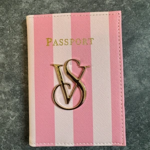 Randig passfodral från Victoria's Secret - Supersnyggt passfodral från Victoria's Secret i rosa och ljusrosa ränder med guldig VS-logga framtill. Helt ny