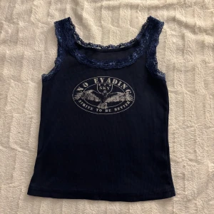 Navy Blue Tank Top - Selling a cute but very tight tank top, worn a few times but is still in good condition. Fits both XS and S and has some loose threads that you can see on the last picture but are easy to just cut. 