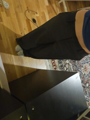 Lågmidjade baggy kostymbyxor - Säljer ett par lågmidjade baggy kostymbyxor i mörkblå grå med svarta tunna ränder