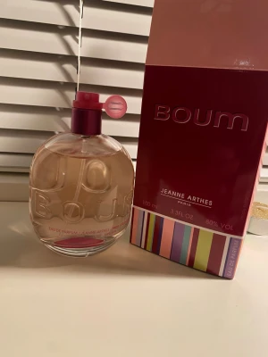 Jeanne arthes perfume - Boum från Jeanne Arthes är en Eau de Parfum på 100 ml med 80% volym. Tillverkad i Frankrike. Förpackningen har en färgglad och lekfull design som passar perfekt för dig som vill ha något unikt och trendigt på hyllan. Ungefär 90% av flaskan är full.