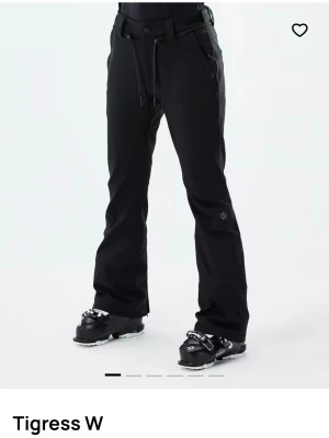 Tigress W skidbyxor från Dope, nypris 1800kr - Säljer mina snygga bootcut skidbyxor från Dope, knappt använda - max 5 gånger, har några små skavanker (se bilder) men syns inte och annars de i princip som nya! Sitter super snyggt över pjäxorna och är varma hela dagen. Har non-slip mudd längst nere så ingen snö kommer in, dragkedja där bak vid foten för att kunna vida benen ännu mer samt väldigt elastiska i midjan så passar de flesta 😊Nypris 1800kr