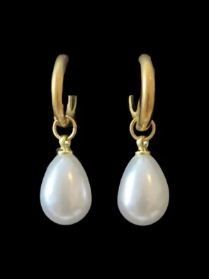 Guldiga örhängen med droppformade pärlor - Finns även i silverfärgad variant. Priset avser ett par örhängen. Material: Rostfritt stål Längd: ca 30 mm Nickelfria och handgjorda.