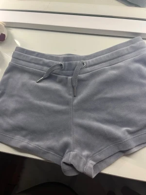 Grå fleece shorts från Gina Tricot - Mysiga grå shorts från Gina Tricot i fleece med snörning i midjan och en bakficka. Perfekta för chill dagar eller som mjuka träningsshorts.