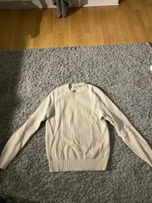 Beige stickad tröja från J.Lindeberg - Säljer en beige stickad tröja från J.Lindeberg i storlek S. Tröjan har ett diskret rutmönster, rund hals och ribbade muddar vid ärmslut och nederkant. Perfekt för dig som gillar stilrena och klassiska plagg med snygg passform. Nypris 700 mitt pris 500. Hör av dig vid frågor eller funderingar🌟