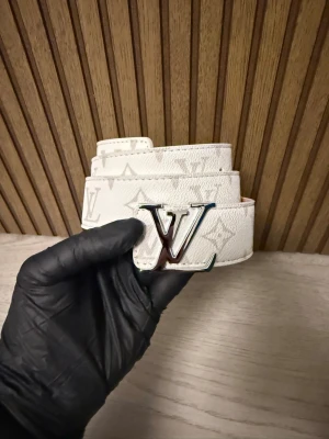 Bälte  - Säljer ett snyggt vitt. Skärpet är gjort i präglat skinn och har en exklusiv känsla som verkligen sticker ut. Perfekt accessoar för att lyfta din outfit.