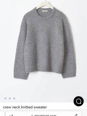 Grå stickad tröja från Gina Tricot - Mysig grå stickad tröja från Gina Tricot med rund hals och ribbade muddar. Tröjan har en loose passform och är långärmad, perfekt för kyliga dagar. Premium Quality-material som känns mjukt mot huden och ger en avslappnad vibe.