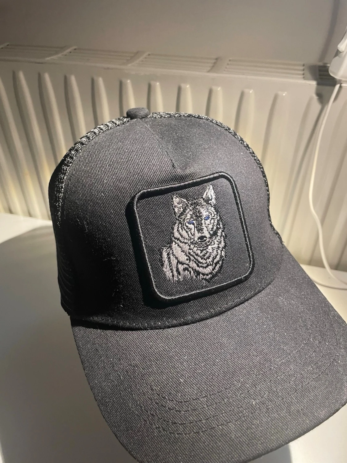 Svart truckerkeps med vargmärke