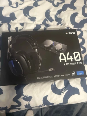 Astro A40 + MixAmp Pro gamingheadset - Astro A40 + MixAmp Pro är ett svart gamingheadset med blå detaljer och over-ear design. Headsetet har en justerbar mikrofon och mjuka öronkuddar. MixAmp Pro ingår för smidig ljudkontroll. Kompatibel med PS4, PC och Mac. Perfekt för gaming och streaming.