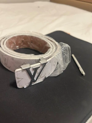 Vitt läder bälte - Vitt läder bälte klassiskt märke o hållalagare ingår 