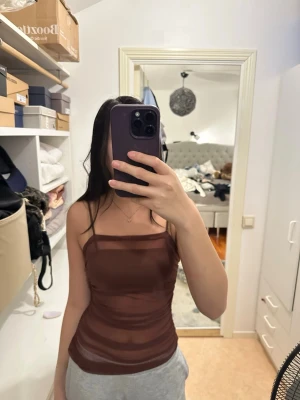 Brun mesh linnetopp med smala band - Säljer en brun, tight mesh linnetopp med smala justerbara axelband. Linnetoppen är genomskinlig och perfekt till fester!! Pris kan diskuteras💓