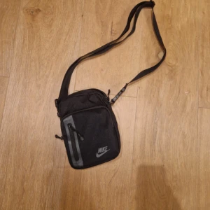 Svart axelväska från Nike - Snygg svart axelväska från Nike med justerbar rem och flera fack. Den är helt oandvänd och inga märken eller hål. Tveka inte om frågor✅