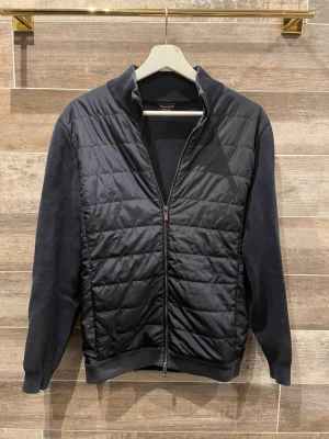 Massimo Dutti cardigan  - Stilren svart overshirt från Massimo Dutti med quiltad front och ärmar i mjuk bomullsmix. Jackan har dragkedja framtill, ribbade muddar och en klassisk ståkrage. Perfekt för lager-på-lager och en clean look.