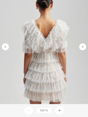 Vit spetsklänning från by Malina - Superfin vit kort klänning från by Malina med volanger i flera lager och v-ringning både fram och bak. Klänningen är gjord i spets och har korta ärmar med volangdetaljer. Perfekt för studenten!! Den har inga deffekter eller fläckar 