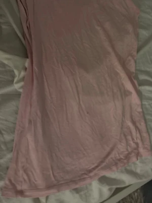 Ljusrosa basic t-shirt - En enkel ljusrosa t-shirt med klassisk passform och rund halsringning. T-shirten är kortärmad och tillverkad i ett mjukt material som känns skönt mot huden. Perfekt att matcha med jeans eller shorts för en avslappnad look.