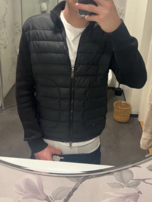 Moncler cardigan - Snygg svart dunjacka från Moncler med quiltat mönster framtill och släta ärmar. Jackan har dragkedja hela vägen och en liten Moncler-logga på ena ärmen. Perfekt för kalla vinterdagar och riktigt stilren look.