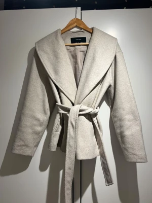 Beige jacka - Beige höst/vår/vinterjacka från Vero Moda inköpt förra året. Väldigt gosig och skärpet går att ta av eller på. Inköpt för 899kr