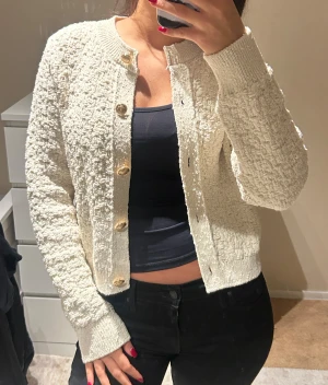 Cremevit kofta med gulda knappar  - Säljer denna cremevita kofta/tröja från H&M, mycket bra skick! I storlek XS, dock lite större i storleken så passar mer som S!!