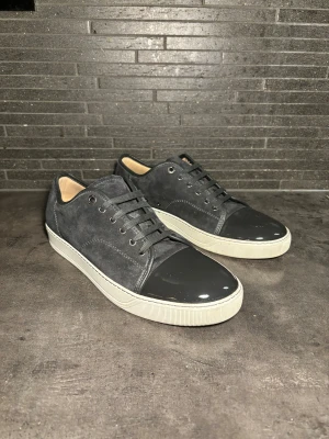 Mörkgrå Lanvin med lackad tå - Säljer nu dessa otroligt snygga och klassiska lanvin skorna i mörkgrå färg. Skorna är i super bra skick använda 3 gånger EJ TVÄTTADE. Storlek uk 10 sitter som EU 44-45 