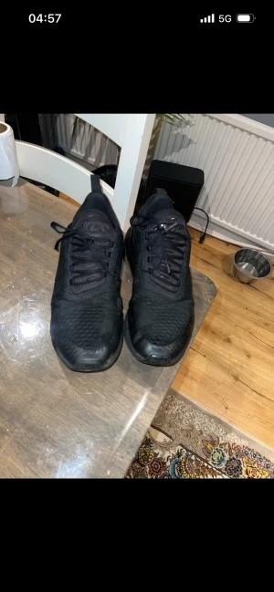 Nike Air Max 270 helsvarta sneakers - Säljer ett par helsvarta Nike Air Max 270 sneakers med mesh- och syntetmaterial, synlig Air Max-dämpning i hälen och klassisk snörning. Snygg sportig look med diskreta detaljer och rund tå. Perfekta för dig som gillar streetwear och komfort.