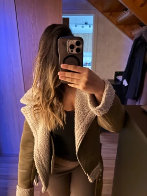 Beige teddyjacka med bälte och dragkedja - Säljer en snygg beige teddyjacka med fluffigt foder och detaljer som bälte i midjan och silvriga dragkedjor. Välanvänd men fortfarande i fint skick. 