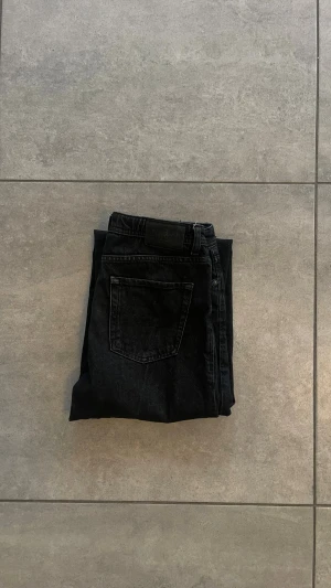 Svarta relaxed jeans från Jack & Jones - Svarta jeans från Jack & Jones i relaxed fit med raka ben. Jeansen har knapp och dragkedja fram, samt bälteshällor. Materialet är robust denim som ger en cool och avslappnad vibe.