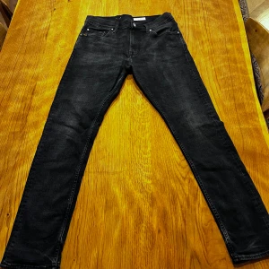 Svarta skinny jeans från Tiger Of Sweden - Säljer ett par svarta jeans från Tiger of Seden med slim passform och klassisk femficksdesign. Jeansen har en mörk tvätt med lätt slitning och raka ben. Använda ett fåtal gånger (färre än 5). Kolla sista bild för rättvis färg. Priset är inte hugget i sten!