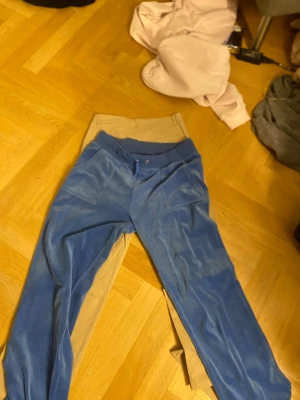 Blå juicy couture byxor - Jag säljer mina blåa juicy couture byxor då jag inte använder dom längre. Ens snöret är lite sönder som man ser och det andra snöret är borta därmed det nedsänkta priset. I och med att det är olika ljus på mina bilder så la jag in en jämförelse bild hur de ser ut och vilken färg det är.